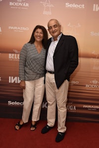 a man and woman standing next to each other on a red carpet