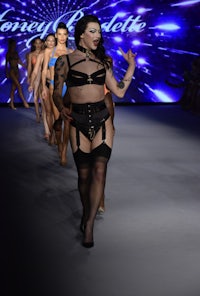 a woman in lingerie walking down the runway