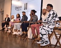 a group of people sitting on chairs in front of a screen