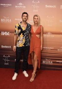 a man and woman standing on a red carpet at an event