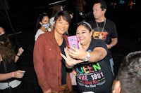 a man takes a selfie with a woman at a concert