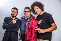 three men posing for a photo with one pointing to the camera