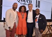 four people posing for a photo at the queen collection event