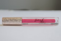 a pink liquid lipstick on a white surface