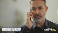 a man on a cell phone with the words pelicula tu mira