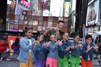 a group of children posing for a photo in times square