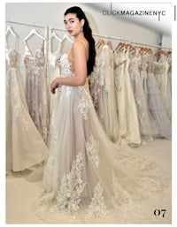 a woman in a wedding dress is standing in front of a rack of dresses