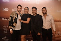 a group of people posing for a picture on a red carpet