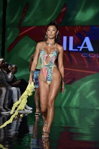 a model walks the runway wearing a bikini