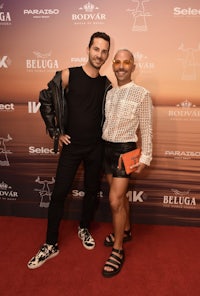 a man and woman standing on a red carpet