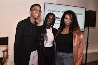 three women posing for a photo in front of a screen