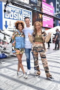 three people posing for a photo in times square