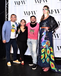 a group of people posing for a photo at a fashion show