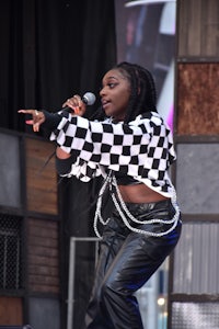 a woman wearing leather pants and a checkered shirt on stage