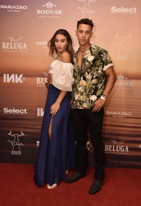 a man and woman posing on a red carpet