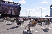 a crowd of people watching a movie on a large screen