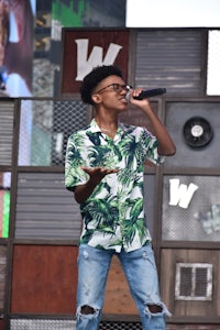 a young man in a green shirt singing into a microphone