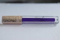 a purple liquid lipstick on a white surface