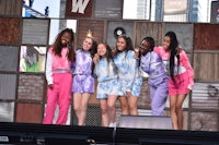 a group of young girls standing on stage at a music festival