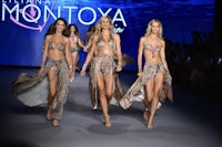 four models walk down the runway at a fashion show