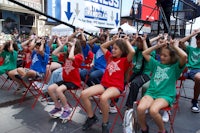 a group of children sitting on chairs in front of a building