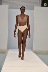 a woman in a bikini walking down the runway