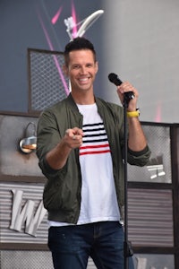 a man in a green shirt is holding a microphone