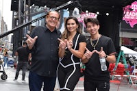 three people posing for a picture in front of a building