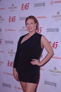 a woman in a black dress posing on the red carpet