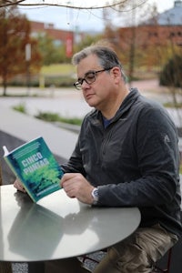 a man sitting at a table reading a book