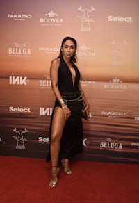 a woman in a black dress standing on the red carpet