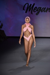 a model wearing a pink bikini on the runway