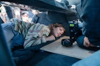 a woman laying in the back of a car with a camera