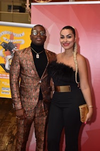 a man and woman standing next to each other on a red carpet