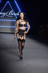 a woman in lingerie walking down the runway