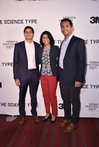 three people posing for a photo at a science type event