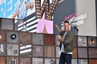 a man posing in front of a large sign