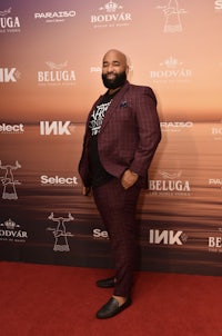 a man in a red suit standing on a red carpet