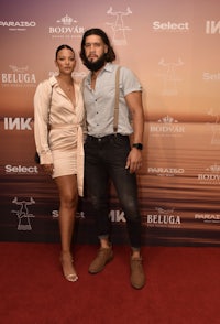 a man and woman posing on a red carpet