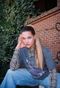 a young woman wearing a grey t - shirt and jeans