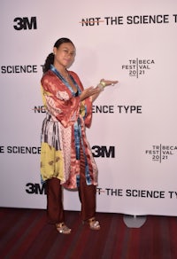 a woman in a kimono standing on a red carpet