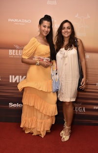 two women standing on a red carpet at an event