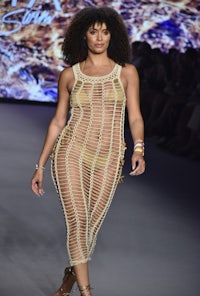 a model walks down the runway in a sheer dress