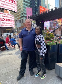 a man and a woman posing for a photo in times square