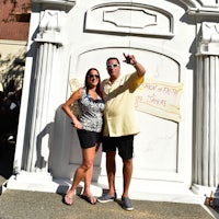 a man and woman posing in front of a monument