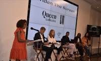 a group of women sitting in front of a screen