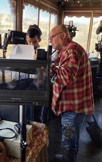 a man in a plaid shirt is working on a camera