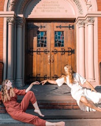 two women laying on the steps of a church