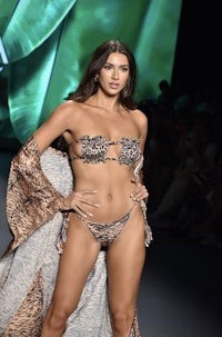 a model walks the runway in a leopard print bikini