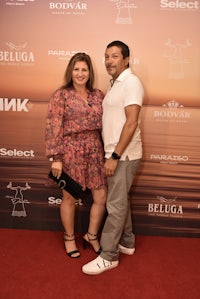 a man and woman standing on a red carpet at an event